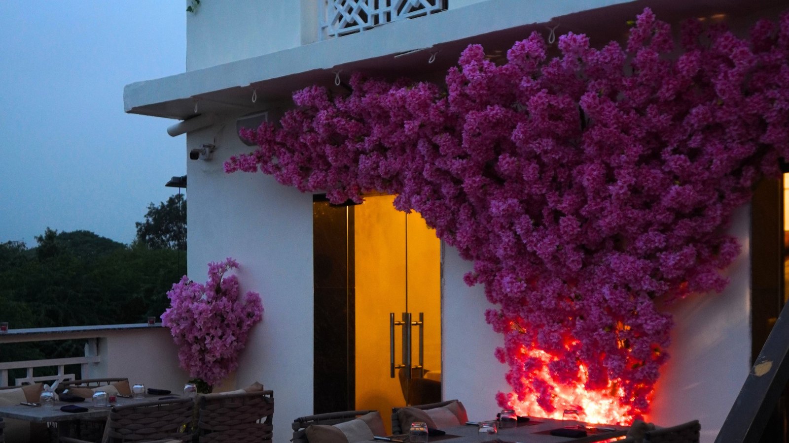 Alora Delhi terrace lounge at night with lit bougainvillea