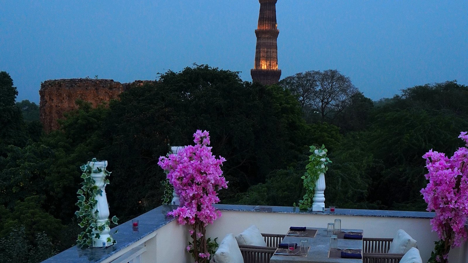 Alora Delhi rooftop dining with Qutub Minar view at dusk