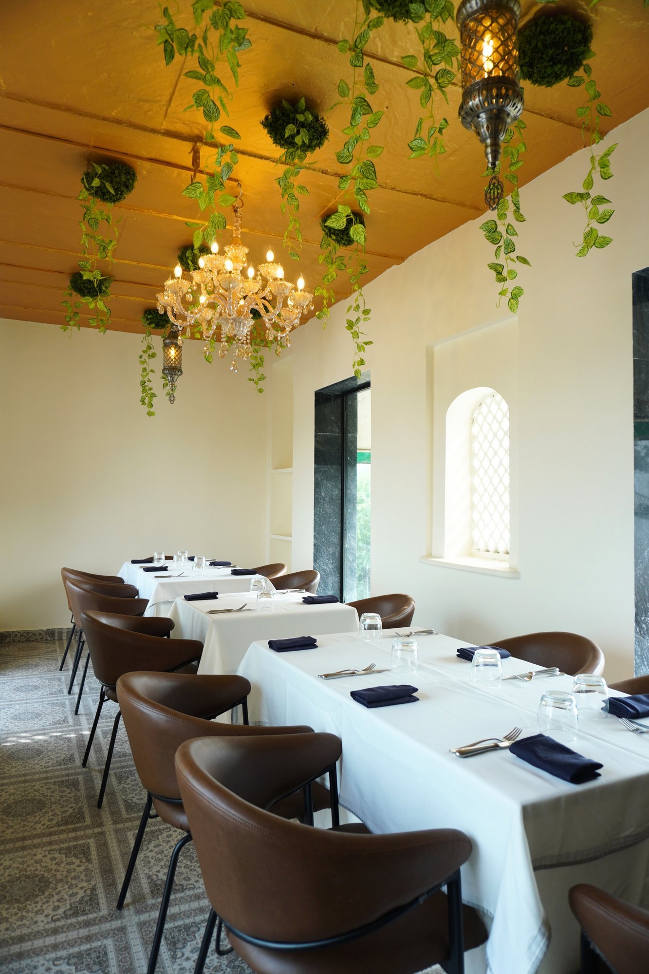 Alora Delhi interior dining hall with chandelier and greenery